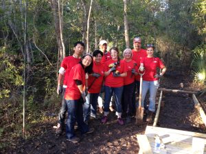 group of smiling volunteers in red shirts